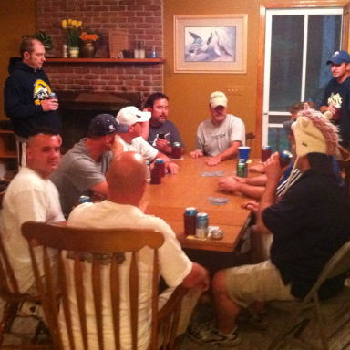 A group of men gathered around a table, socializing in a casual setting.
